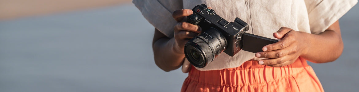 Comparatif appareils APS-C Sony - personne tenant un appareil de la série Sony A6000